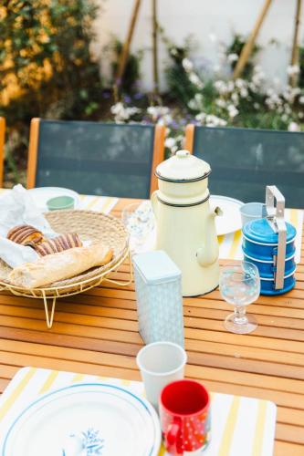 - une table en bois avec des assiettes et de la vaisselle dans l'établissement La Villa Ralph - Beach - Trouville, à Trouville-sur-Mer
