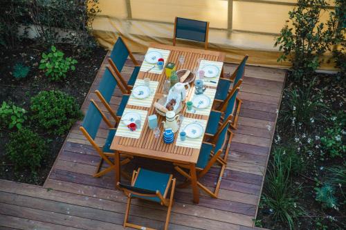 Elle offre une vue sur une table et des chaises en bois. dans l'établissement La Villa Ralph - Beach - Trouville, à Trouville-sur-Mer