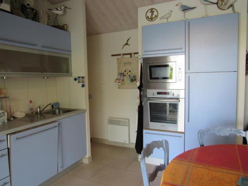 Il comprend une cuisine équipée d'un réfrigérateur et d'une cuisinière. four supérieur dans l'établissement Maison moderne 6 pers, proche mer, La Faute-sur-Mer - FR-1-194-271, à La Faute-sur-Mer