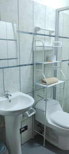 a white bathroom with a toilet and a sink at Mini depa estreno 4 piso in Puerto Maldonado