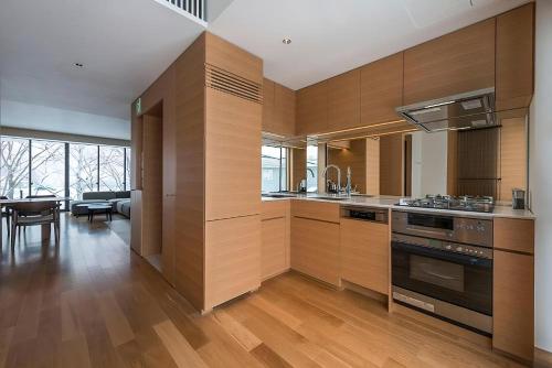 a kitchen with wooden cabinets and a dining room at Kozue in Kutchan