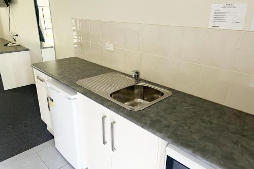 a kitchen with a sink and a counter at Tocumwal Early Settlers Motel in Tocumwal