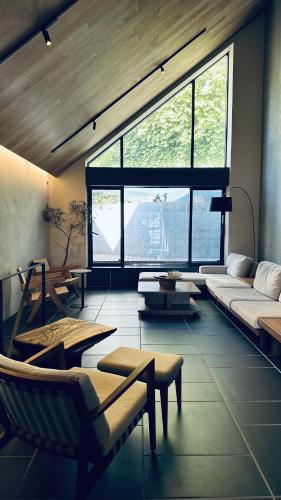 a living room with a couch and a chair at Kakurega Tokyo villa in Tokyo