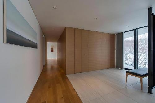 a living room with a bench and a large window at Kozue in Kutchan