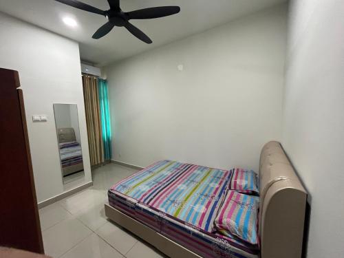 a bedroom with a bed and a ceiling fan at Homestay Anggun in Kuala Kerai