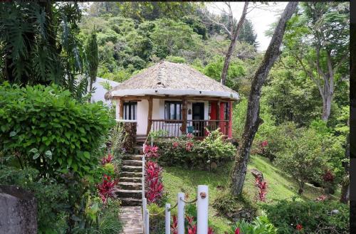 a small house in a garden with a fence at Villa La Fortuna Altos del Maria in Filipina