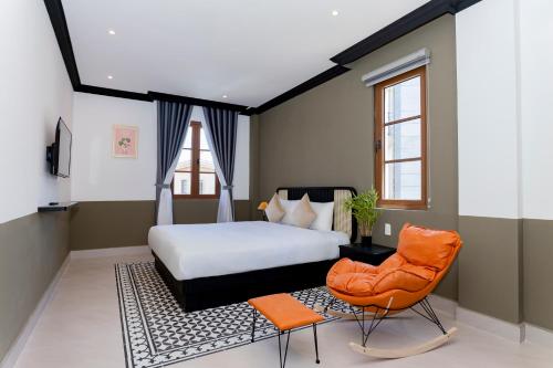 富国SUNSET BAY RETREAT的一间卧室配有一张床和一张橙色椅子