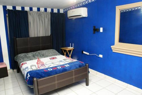 1 dormitorio con 1 cama con pared azul en Encantadora casa con 3 habitaciones frente al parque en Hermosillo