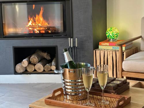 a table with two glasses of champagne in front of a fireplace at Les Turquoises Étretat - L'Hôtel-Boutique in Étretat