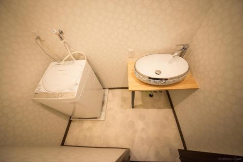 a bathroom with a sink and a washing machine at カモンイン 稲荷 in Kyoto