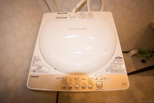 a white toilet in a bathroom with the lid up at カモンイン 稲荷 in Kyoto