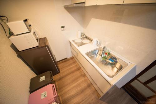 a small kitchen with a sink in a room at カモンイン 稲荷 in Kyoto
