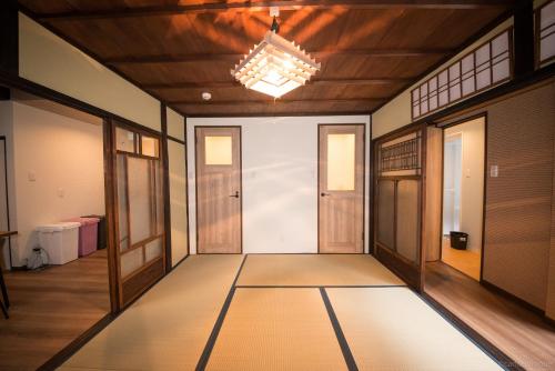 a hallway with a door and a chandelier at カモンイン 稲荷 in Kyoto