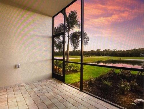 a room with a window with a view of a golf course at GOLF Paradise!-Lakewood National -Beautiful Resort -Palmer's Cove Condo in Bradenton