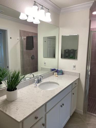 a bathroom with a sink and a large mirror at GOLF Paradise!-Lakewood National -Beautiful Resort -Palmer's Cove Condo in Bradenton