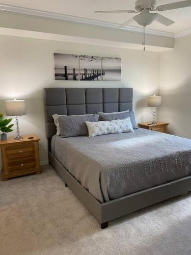 a bedroom with a large bed and two night stands at GOLF Paradise!-Lakewood National -Beautiful Resort -Palmer's Cove Condo in Bradenton