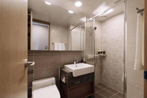 a bathroom with a sink and a toilet and a mirror at Gunamro Hotplace 3min Haeundae beach in Busan