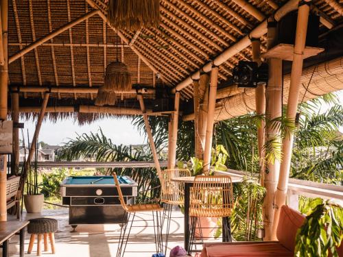 an outdoor patio with chairs and a grill at Clandestino Hostel Canggu in Canggu