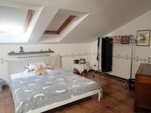 um quarto com uma cama com um urso de peluche em La stanza dello Scirocco em Celle Ligure