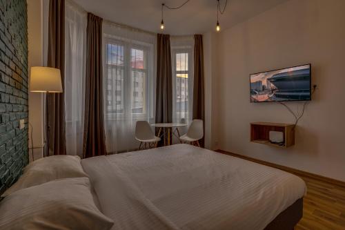 um quarto com uma cama, uma mesa e janelas em Apartamenty Centrum Dworzec PKP self check-in 24h em Katowice