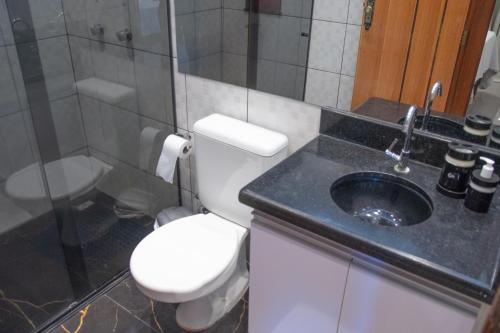 a bathroom with a toilet and a sink at Apto a 300m da praia AxéMoi in Porto Seguro