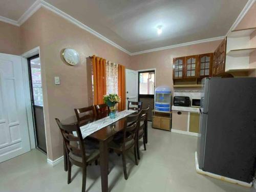 eine Küche mit einem Tisch und Stühlen sowie einem Kühlschrank in der Unterkunft Mi Casa Gensan - Beautiful 2BR house with wifi & netflix in General Santos