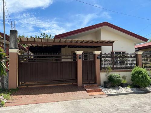 a house with a wooden gate and a fence at Mi Casa Gensan - Beautiful 2BR house with wifi & netflix in General Santos