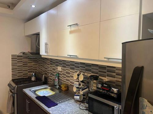 a kitchen with white cabinets and a counter top at Apartamento amueblado. in Santiago de los Caballeros