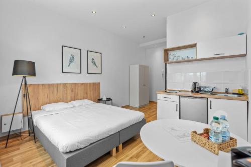 a bedroom with a bed and a table and a kitchen at Apartamenty Centrum Zameldowanie 24h in Katowice