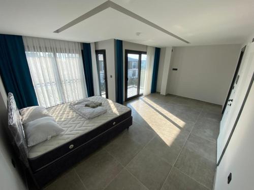 1 dormitorio con 1 cama en una habitación con ventanas en Villa Ögreten, en Aydın