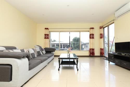 a living room with a couch and a television at Tropical Plaza Apt in Nadi