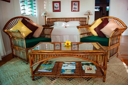 a living room with two chairs and a table and a bed at Nukubati Great Sea Reef in Nukubati