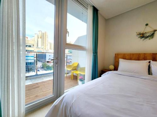 um quarto com uma cama e uma grande janela em Well stay em Incheon