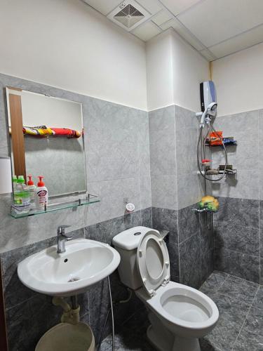y baño con aseo y lavamanos. en MADLAD SPACE homestay, en Kinh Dinh