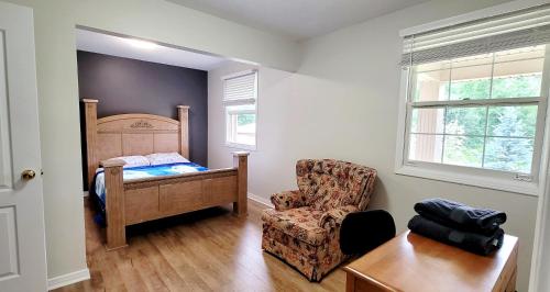 1 dormitorio con 1 cama, 1 silla y 1 mesa en Niagara Falls Villa with Private pool, hottub, water view and Breakfast, en Niagara Falls