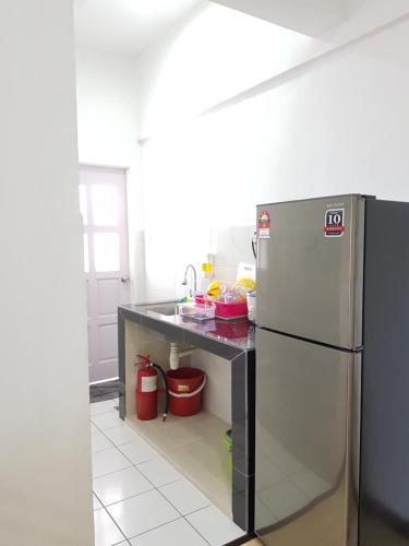 a kitchen with a stainless steel refrigerator and a counter at Locahouz Homestay Sandakan in Sandakan