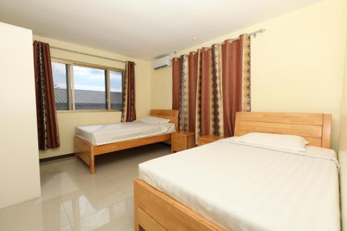- une chambre avec 2 lits et une fenêtre dans l'établissement Tropical Plaza Apt, à Nadi