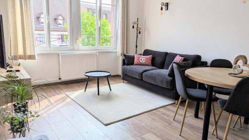 Appartement Chez Mar'Tine في نيديربرون ليه باينس: غرفة معيشة مع أريكة وطاولة