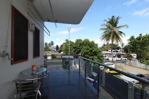 a balcony with a table and a view of a parking lot at Tropical Plaza Apt in Nadi