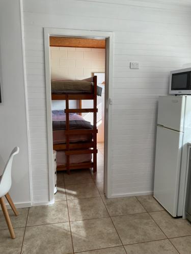 a room with a bunk bed and a refrigerator at Marlo Hideaway in Marlo
