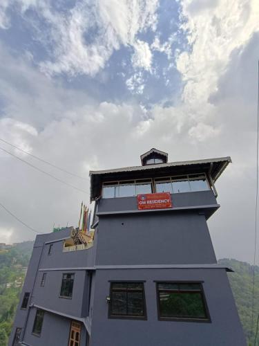 a building with a sign on the top of it at Hotel Om Residency in Darjeeling