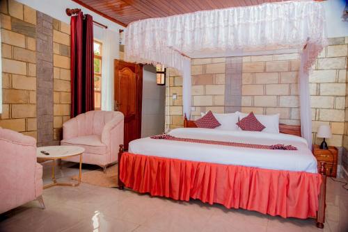 una camera con un grande letto e una sedia di KIGUFI HILL, Agape Resort & Kivu Edge a Gisenyi