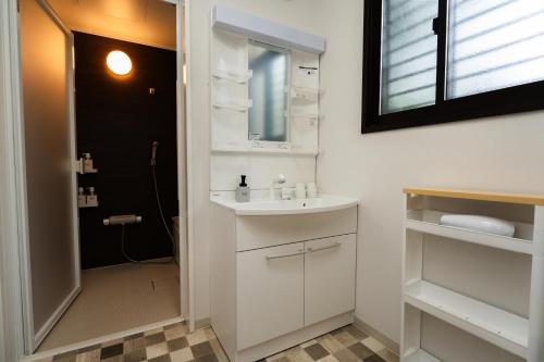 a white bathroom with a sink and a mirror at YOICHI inn HAKONE in Hakone