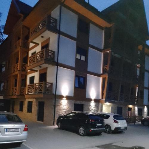 a building with cars parked in front of it at Idila Lux in Zlatibor