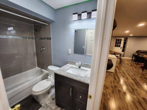 a bathroom with a sink and a toilet and a bath tub at Adorable 2-Bedoom walkout basement Apartment in Milton