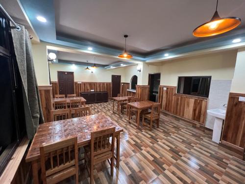 a large room with wooden tables and chairs at Hotel Om Residency in Darjeeling