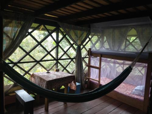 een kamer met een hangmat in een boomhut bij Lomón de los Zipas Amazónicos in Puerto Nariño