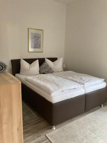a bed with white sheets and pillows in a room at Haus Brandenburg in Stechlin