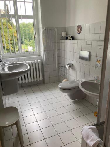 a bathroom with two sinks and a toilet and a window at Haus Brandenburg in Stechlin