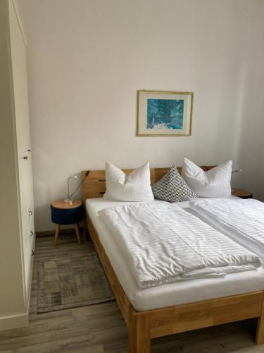 a bedroom with a bed with white sheets and pillows at Haus Brandenburg in Stechlin
